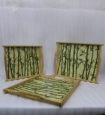 Set of wooden serving trays with printed bamboo stalk patterns resting on a kitchen countertop.