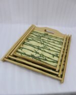 Set of wooden serving trays with printed bamboo stalk patterns resting on a kitchen countertop.