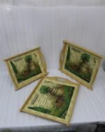 Set of three rectangular natural wooden serving trays with side handles featuring a printed rustic garden scene resting on a marble kitchen countertop.