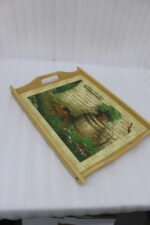 Set of three rectangular natural wooden serving trays with side handles featuring a printed rustic garden scene resting on a marble kitchen countertop.
