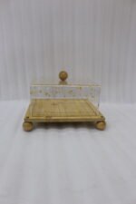 Square bamboo cake stand with gold flecked acrylic dome cover set on a kitchen counter