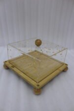 Square bamboo cake stand with gold flecked acrylic dome cover set on a kitchen counter