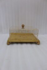 Square bamboo cake stand with gold flecked acrylic dome cover set on a kitchen counter