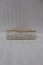 Clear acrylic tissue box holder embedded with gold flakes and a textured beige lid sitting on a wooden table