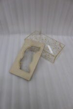 Clear acrylic tissue box holder embedded with gold leaf flakes and topped with a textured light gold lid on a wooden coffee table.