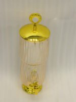 3.5L ribbed pink glass beverage dispenser with ornate gold base, spout, and top handle standing on a kitchen marble countertop