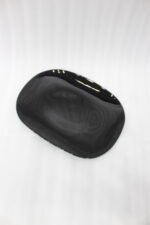 Glossy black 38-piece ceramic dinner set arranged on a rustic wooden dining table near a bright window.