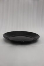 38-piece glossy black opal glass dinner set displayed on a wooden dining table, featuring plates, bowls, cups, and serving dishes.