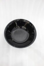 38-piece glossy black opal glass dinner set displayed on a wooden dining table, featuring plates, bowls, cups, and serving dishes.