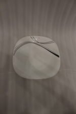 White opal glass dinner set with minimalist black linear wave design displayed on a kitchen island
