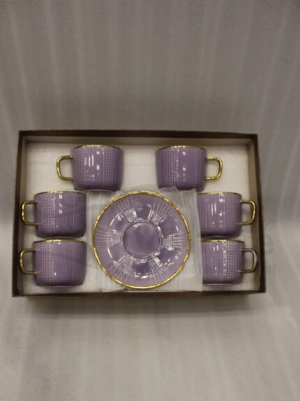 Luxury purple and gold 6-person cup and saucer set neatly arranged in a presentation box on a kitchen counter.