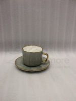 A luxury 6-person sage green ceramic cup and saucer set with gold trim, neatly packed in a gift box on a kitchen counter.