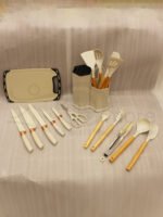 19-piece cream silicone kitchen utensil and knife set with wooden handles arranged in a matching ribbed counter holder