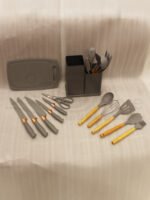 Modern grey 19-piece silicone kitchen utensil and knife set with wooden handles in a matching storage caddy on a countertop