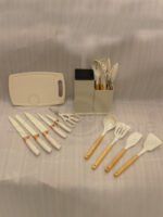Off-white 19-piece silicone kitchen utensil and knife set with rose gold accents sitting in a dual caddy block on a countertop.