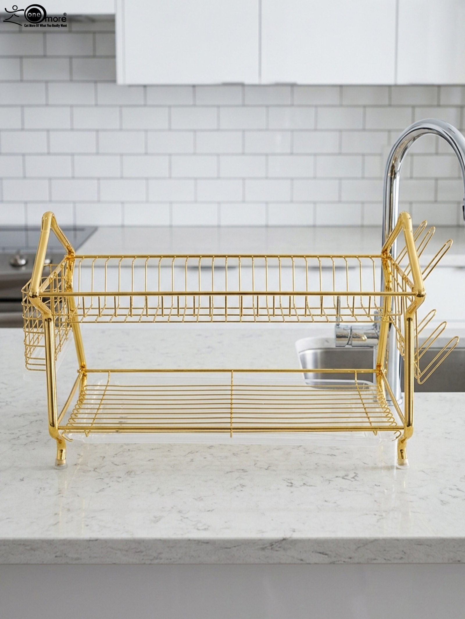 1 2 tier luxury gold metal dish drying rack with utensil basket, glass holder hooks, and clear drip tray on a kitchen countertop next to a faucet.