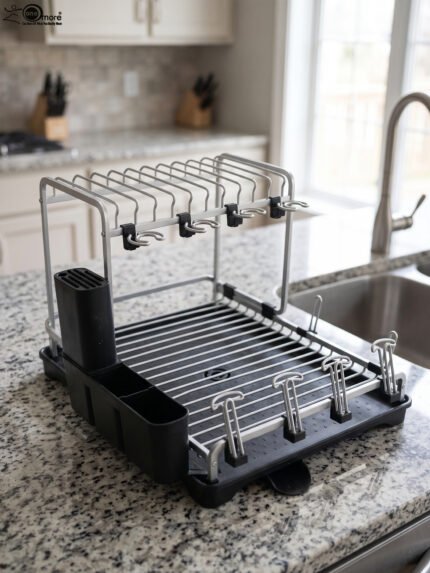 Modern 2-tier stainless steel dish drying rack with integrated knife block, utensil caddy, cup holders, and drainage tray on a granite countertop next to the sink.