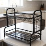 2-tier black metal dish drying rack with removable drain tray and side utensil holder on a kitchen countertop