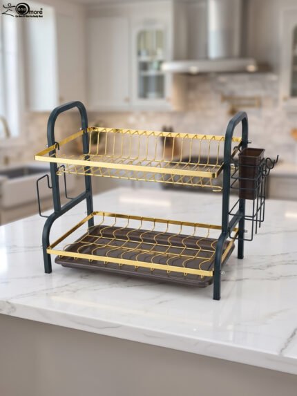 Two-tier gold and black metal dish drying rack with removable drip tray and utensil holder on a white marble kitchen countertop.