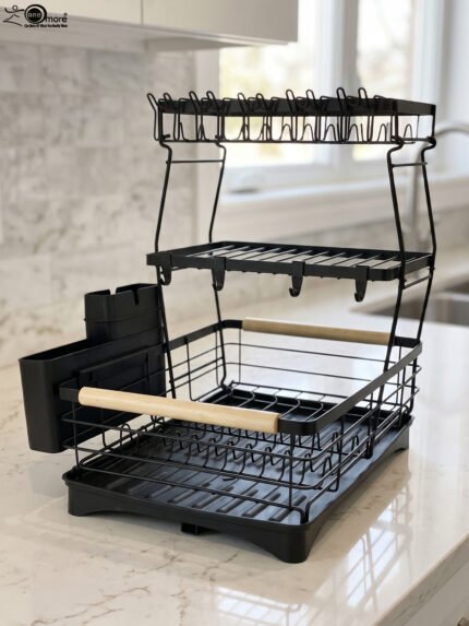 3-tier black wire dish drying rack on a marble countertop with wooden handles, attached utensil holder, and removable drip tray