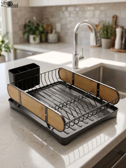 Matte black metal dish drying rack with natural wooden side accents, a black cutlery holder, and a removable drip tray sitting next to a kitchen sink.