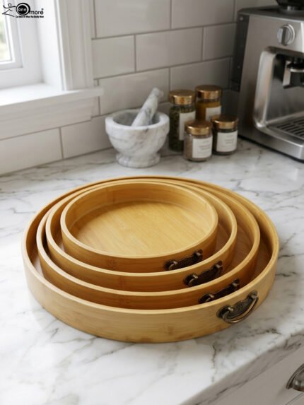 4-piece round wooden nesting serving tray set with built-in cut-out handles stacked on a white kitchen countertop