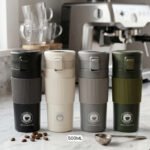 Four 500ml thermal travel coffee mugs in black, cream, grey, and olive green with silicone grips on a kitchen counter