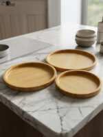 3-piece nested round wooden serving tray set made of natural bamboo displayed on a marble kitchen countertop