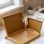 3 piece natural bamboo wooden serving tray set with cut-out side handles on a marble kitchen countertop
