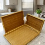 3 piece rectangular wooden serving tray set with built-in cutout handles displayed on a marble kitchen countertop