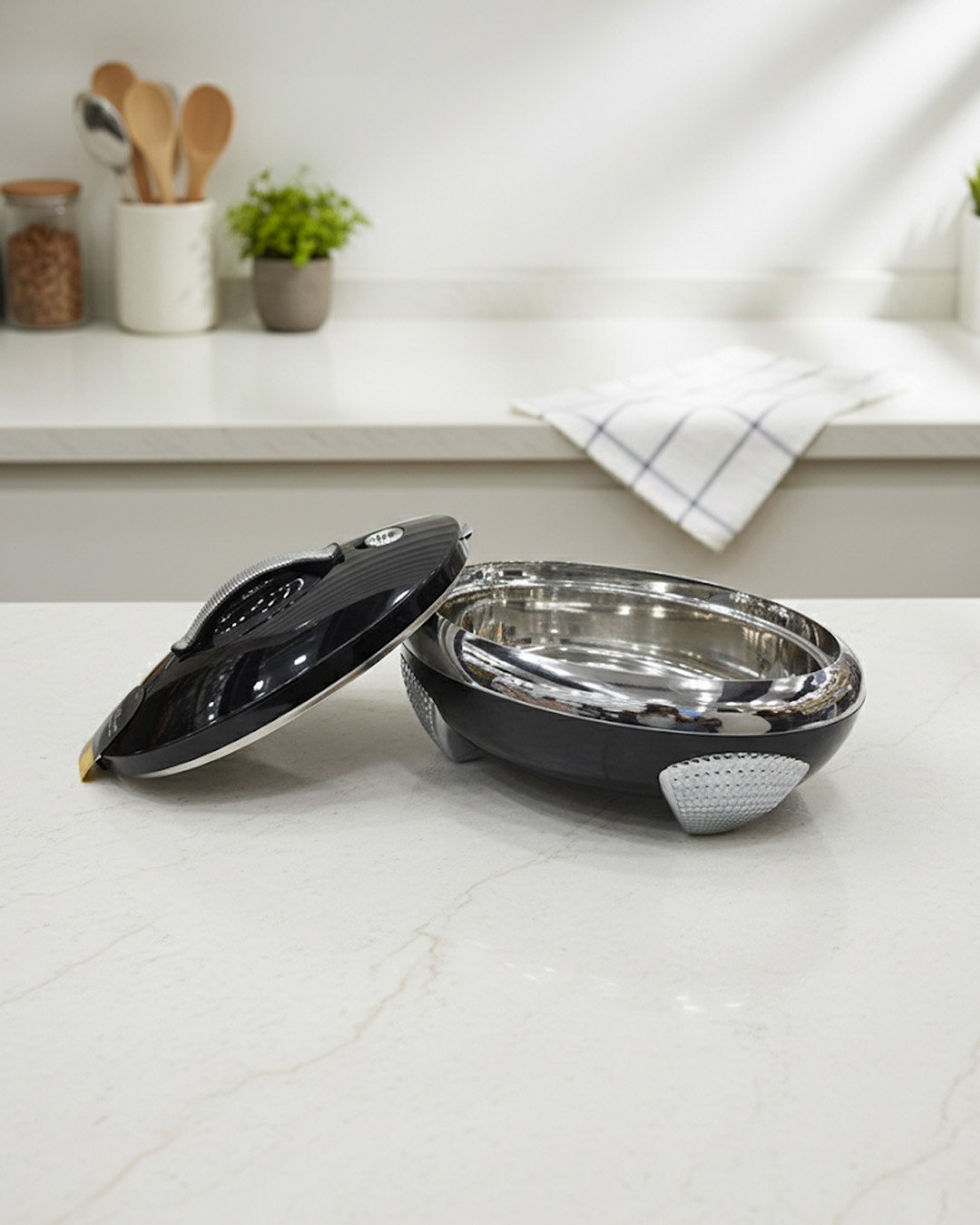 1 Glossy black insulated stainless steel hotpot casserole with silver chrome accents and lid open on a kitchen countertop.