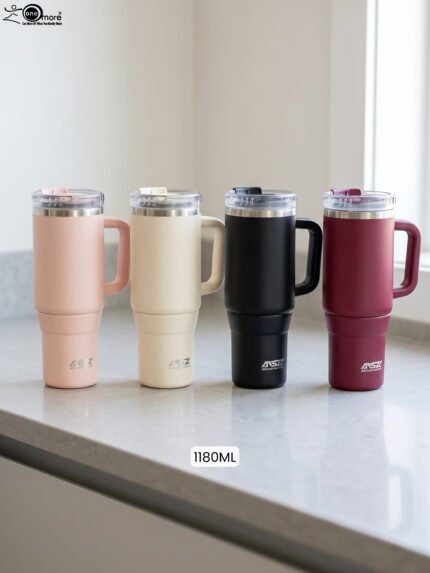 Four 1180ml insulated stainless steel tumblers with handles and clear lids in pink, cream, black, and burgundy lined up on a kitchen counter.