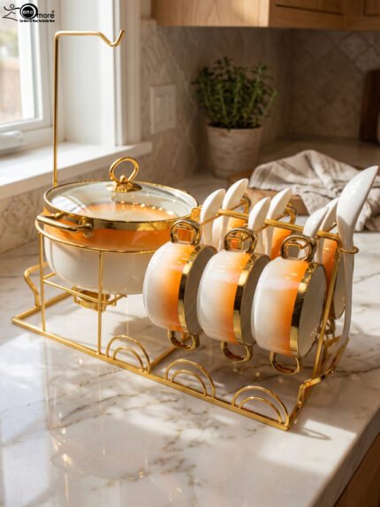 Ceramic soup tureen set with orange gradient rims and gold accents, including hanging soup cups, saucers, and spoons organized on a gold metal rack.