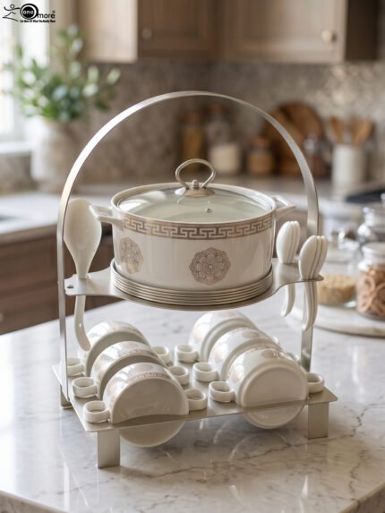 White ceramic soup tureen with glass lid, matching dual-handled soup bowls, saucers, and spoons organized on a two-tier gold metal rack.