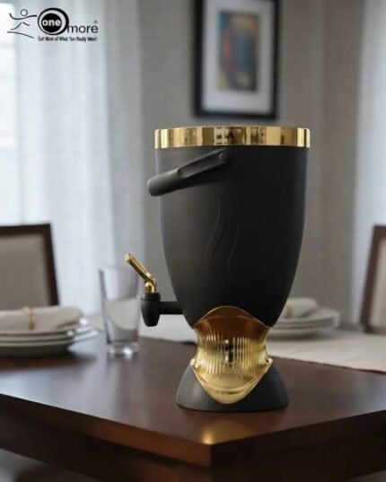 Matte black 5.5L beverage cooler dispenser with gold metallic accents, top handle, and dispensing tap resting on a dining table