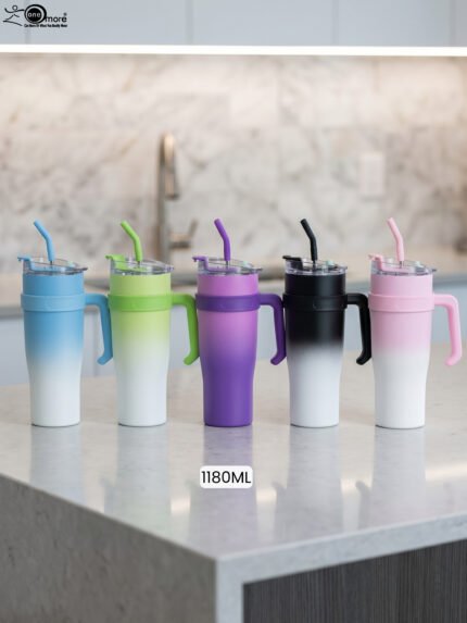 Five 1180ml ombre stainless steel tumblers with handles and straws in blue, green, purple, black, and pink lined up on a marble kitchen counter.