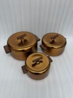 3-piece matte gold thermal hot pot set with dark wooden handles on a marble kitchen countertop
