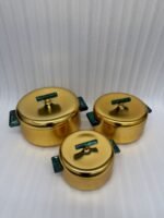 Three-piece luxury brushed gold insulated hot pot set with emerald green handles displayed on a marble kitchen countertop