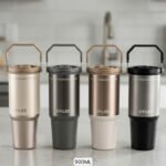 Four UYLEE 900ml stainless steel insulated travel tumblers with flexible handles displayed in neutral colors on a countertop.