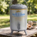 DAYDAYS 9.5-liter gray thermal beverage dispenser jug with dispensing tap and tripod stand sitting on an outdoor wooden picnic table.