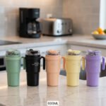 Lineup of five 600ml insulated travel coffee tumblers with handles in green, black, peach, yellow, and purple.