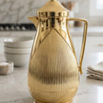 1-Liter metallic gold insulated vacuum flask with fluted ribbed design on a marble countertop