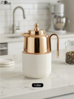 One More 1 Liter white fluted thermal flask with a polished rose gold lid, spout, and ergonomic handle on a kitchen countertop.