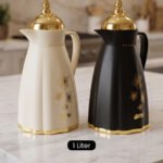 Cream and black 1 liter luxury thermal flasks with ornate gold lids and floral motifs on a marble kitchen countertop.Cream and black 1 liter luxury thermal flasks with ornate gold lids and floral motifs on a marble kitchen countertop.Cream and black 1 liter luxury thermal flasks with ornate gold lids and floral motifs on a marble kitchen countertop.