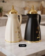Cream and black 1 liter luxury thermal flasks with ornate gold lids and floral motifs on a marble kitchen countertop.Cream and black 1 liter luxury thermal flasks with ornate gold lids and floral motifs on a marble kitchen countertop.Cream and black 1 liter luxury thermal flasks with ornate gold lids and floral motifs on a marble kitchen countertop.