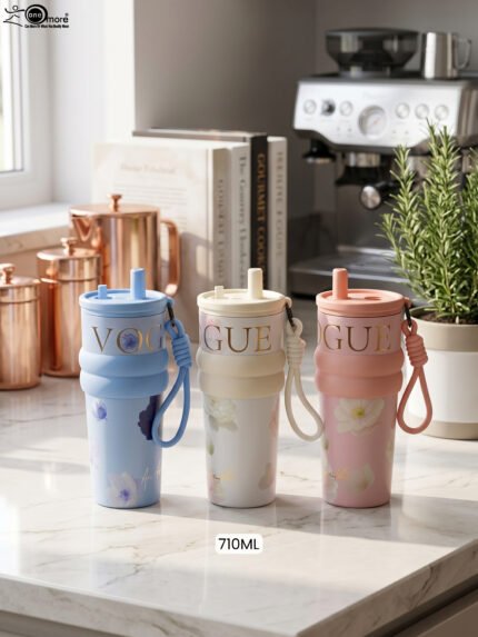 Three 710ml One More VOGUE aesthetic water bottles in pastel blue, cream, and pink featuring straw lids, carrying straps, and floral prints on a kitchen counter.