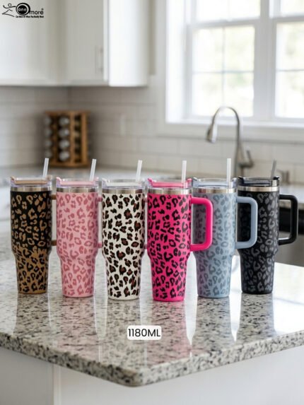 Six 1180ml leopard print insulated travel tumblers with handles and straws displayed in various colors on a kitchen counter.