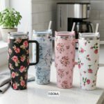 Four 1180ml floral printed insulated tumblers with handles and reusable straws standing on a kitchen counter.
