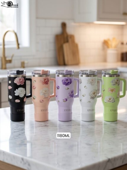 Five 1180ml floral stainless steel travel tumblers with handles in black, peach, lavender, white, and sage green displayed on a kitchen counter.