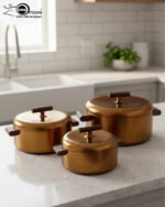 3-piece matte gold thermal hot pot set with dark wooden handles on a marble kitchen countertop
